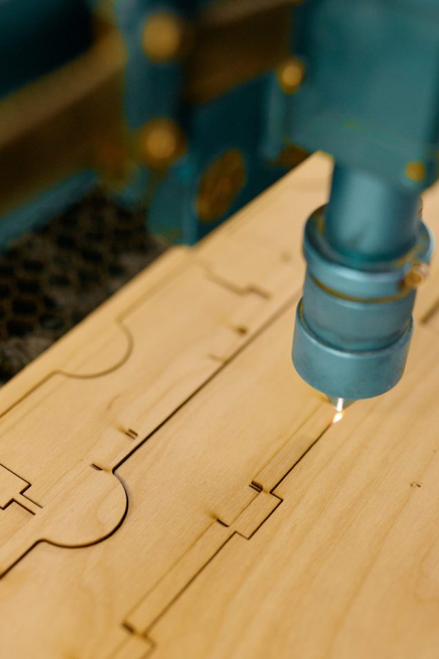 Closeup automated CNC laser machine operating with wooden plank. Woodworking, cutting and engraving process